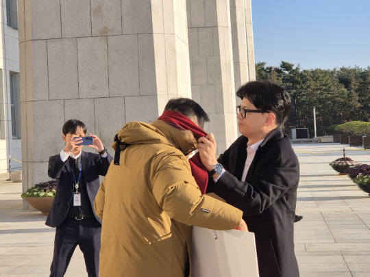 한동훈 국민의힘 대표가 14일 국회 본청 앞에서 김상욱 국민의힘 의원에게 목도리를 둘러주고 있다. [의원실 제공]