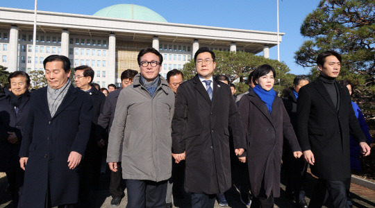 더불어민주당 의원들이 14일 오전 국회 앞에서 탄핵 촉구 집회에 참석한 시민들에게 인사하기 위해 이동하고 있다. 연합뉴스