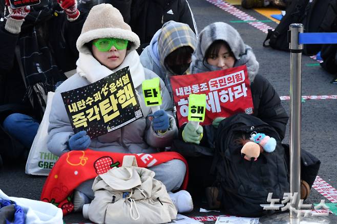 윤석열 대통령 탄핵소추안 재표결을 앞둔 14일 오후 서울 여의도 국회의사당 앞에서 시민들이 탄핵을 촉구하는 집회를 갖고 있다. 류영주 기자