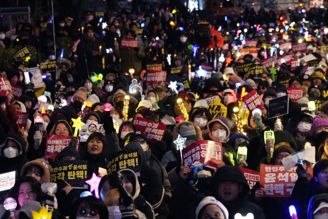 윤석열 대통령 탄핵안 2차 표결을 하루 앞둔 13일 밤 서울 여의도 국회의사당 앞에서 시민들이 윤 대통령의 탄핵을 촉구하는 집회를 하고 있다./AP연합뉴스