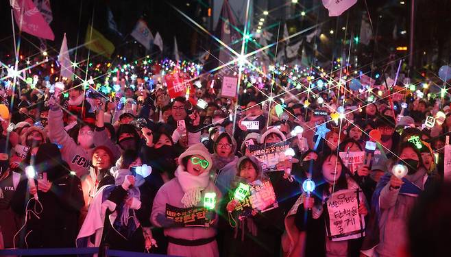 윤석열 대통령 탄핵소추안이 가결된 14일 서울 여의도 국회 앞에서 열린 탄핵 촉구 집회에 참석한 시민들이 기뻐하며 노래를 따라부르고 있다. 연합뉴스