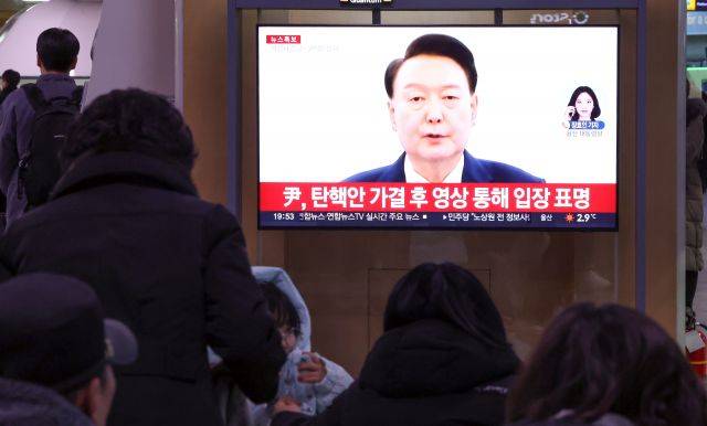 윤석열 대통령의 탄핵소추안이 국회에서 가결된 지난 14일 오후 서울역에서 시민들이 윤석열 대통령의 대국민 담화를 TV를 통해 지켜보고 있다. 연합뉴스