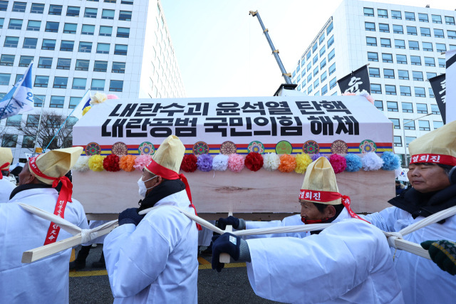 14일 서울 영등포구 여의도 국회 앞에서 열린 윤석열 대통령 탄핵 촉구 집회에서 참가자들이 상여를 운반하는 퍼포먼스를 하고 있다.연합뉴스