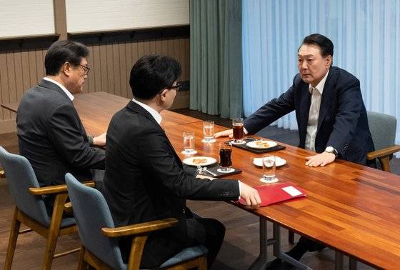 윤석열 대통령이 10월 21일 서울 용산 대통령실 앞 파인그라스에서 국민의힘 한동훈 대표를 만나 대화하고 있다.   이 자리에는 정진석 대통령 비서실장이 배석했다. 연합뉴스
