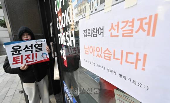 윤석열 대통령 탄핵소추안 표결일인 14일 국회 인근 한 카페에 집회참여 선결제 음료를 알리는 안내문이 부착되어 있다. 2024.12.14 홍윤기 기자