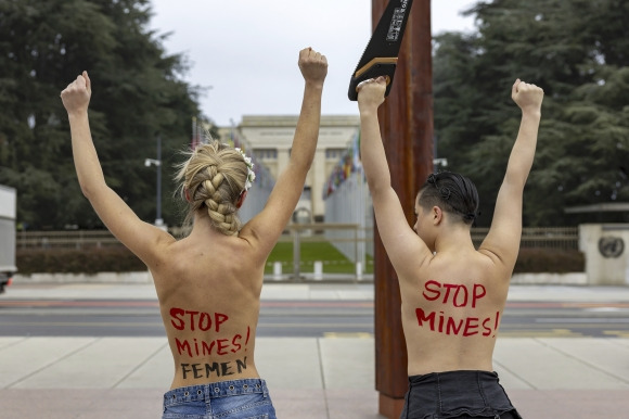 13일(현지시간) 페미니스트 단체 페멘(Femen) 활동가들이 스위스 제네바 유엔유럽본부 앞 광장의 ‘부서진 의자’ 기념비 아래에서 러시아의 유엔 추방을 요구하는 시위를 벌이고 있다. AP 연합뉴스