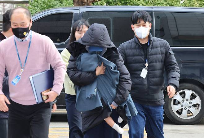 고 이선균씨를 생전에 협박해 금품을 뜯은 혐의가 있는 박모씨가 2023년 12월28일 구속 전 피의자 심문을 받기 위해 어린 자녀를 안은 채 인천지법에 출석하고 있다. (사진 = 연합뉴스 제공)
