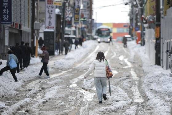 지난달 28일 경기 의왕시 도깨비시장 인근에서 시민들이 많은 눈이 내린 뒤 생긴 빙판길을 조심스럽게 걷고 있다. 뉴시스