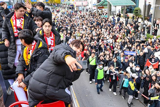 ▲ KIA 타이거즈 선수들이 지난 11월 30일 광주 시내에서 진행된 우승 카퍼레이드 행사에서 팬들과 인사를 나누고 있다. 올해 정규시즌 MVP를 차지한 KIA의 간판타자 김도영이 시민들을 배경으로 셀카를 찍고 있다. ⓒKIA 타이거즈