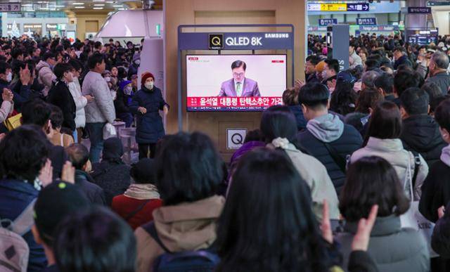 14일 서울 용산구 서울역 대합실에서 시민들이 윤석열 대통령에 대한 국회의 탄핵소추안이 가결되는 순간을 지켜보고 있다. 뉴스1