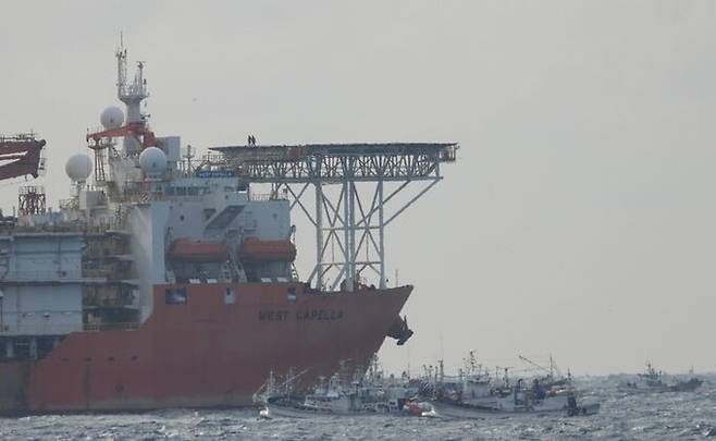 동해 심해 가스·석유전 개발사업인 '대왕고래' 탐사 시추선 '웨스트 카펠라호'가 20일 경북 포항시 남구 구룡포 앞 바다에서 시추 작업에 돌입한 가운데 홍게 잡이 어선들이 해상 시위를 하고 있다.구룡포연안홍게선주협회·홍게통발협회는 이날 기자회견을 열고 탐사 구역이 홍게 어장과 겹친다고 반발하며 탐사시추를 즉각 중단하라고 촉구했다. 포항해양경찰서