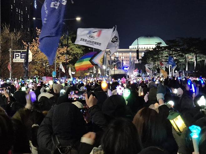 지난 12월 7일 여의도 국회의사당 앞에서 시민들이 아이돌 응원봉, 깃발 등을 들고 집회에 참여하고 있다. 송선교 인턴기자