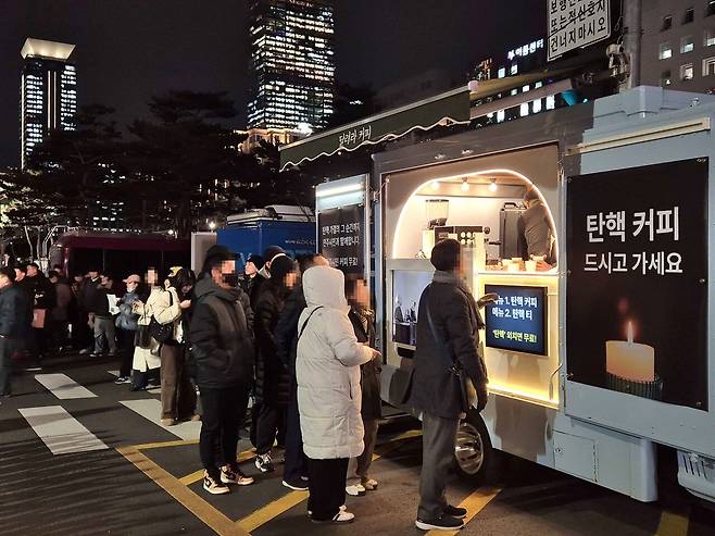 시민들이 집회 중 무료 커피를 받기 위해 줄을 섰다. 이날 커피차 사장 안준호 씨는 아들과 단둘이서 커피 1000잔을시민들에게 나눠줬다. 송선교 인턴기자