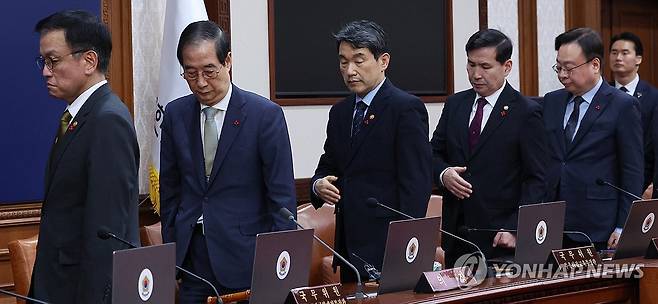 임시 국무회의 참석한 국무위원들 (서울=연합뉴스) 한상균 기자 = 한덕수 대통령 권한대행 국무총리와 국무위원들이 19일 정부서울청사에서 열린 임시 국무회의에서 국민의례 후 자리에 앉고 있다. 2024.12.19 [대통령통신사진기자단] xyz@yna.co.kr