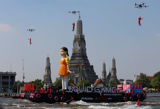 21일(현지 시각) 태국 방콕에서 열린 '오징어 게임' 시즌 2 홍보 행사에서 세계 최대 규모의 영희 인형이 왓 아룬 사원 앞에 전시됐다. /EPA 연합뉴스