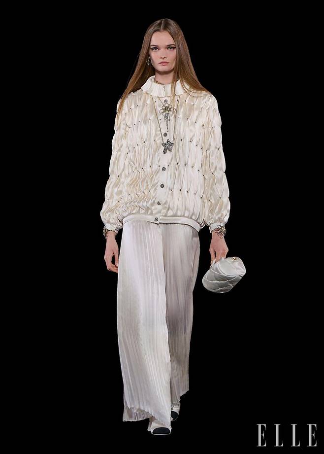 깃털과 플라워 장식을 전문으로 하는 르마리에 공방과 플리츠 장인인 로뇽 공방이 함께 제작한 블랙 드레스, 실크 새틴 재킷과 스커트.