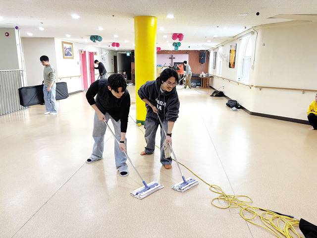 국민일보 김동규(왼쪽) 기자가 걸레질을 하는 모습. 천사의집 제공