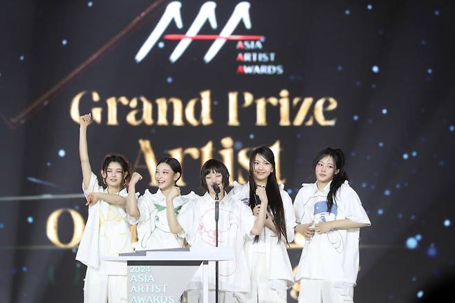 [서울=뉴시스] 그룹 '뉴진스'가 27일 오후 태국 방콕 임팩트 챌린저 홀 1-2(IMPACT Challenger Hall 1-2)에서 열린 '제9회 아시아 아티스트 어워즈'(The 9th Asia Artist Awards·'AAA 2024')에서 대상을 받고 있다. (사진 = AAA 조직위원회 제공) 2024.12.27. photo@newsis.com *재판매 및 DB 금지