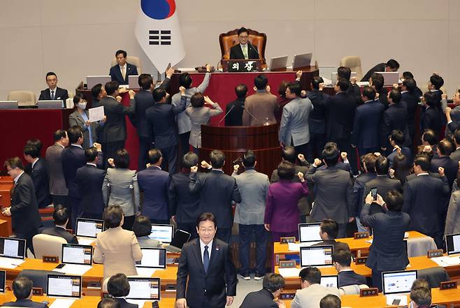 이재명 더불어민주당 대표가 27일 오후 국회 본회의에서 국민의힘 의원들이 우원식 국회의장에게 항의하는 동안 한덕수 국무총리 탄핵소추안에 투표한 뒤 자리로 향하고 있다. 연합뉴스