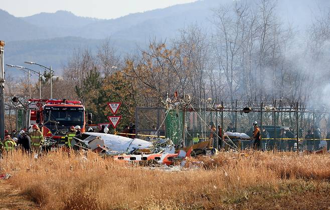 29일 오전 전남 무안국제공항에서 착륙 중이던 항공기가 활주로를 이탈해 울타리 외벽을 충돌했다. 사진은 사고 현장에서 소방 당국이 인명 구조를 하는 모습.   [연합]