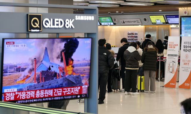무안 제주항공 참사가 발생한 지난 29일 서울 강서구 김포국제공항 국내선 청사에서 관련 뉴스가 나오는 가운데 승객들이 탑승 수속을 하고 있다. 연합뉴스