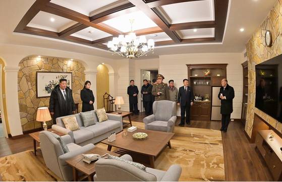 North Korean leader Kim Jong-un, alongside his daughter, inspects the interior of a hotel room in the Kalma coastal tourist area in the country's east coastal city of Wonsan, in this photo published by the Korean Central News Agency on Dec. 31. [YONHAP]