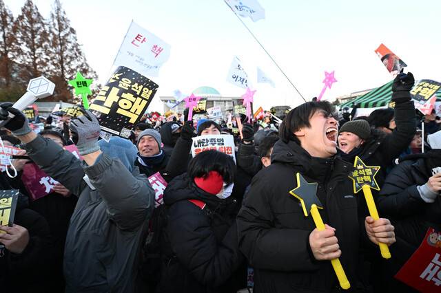 윤석열 대통령 탄핵소추안이 통과된 지난 14일 서울 여의도 국회 앞에 모인 시민들이 환호성을 지르고 있다. 이한형 기자