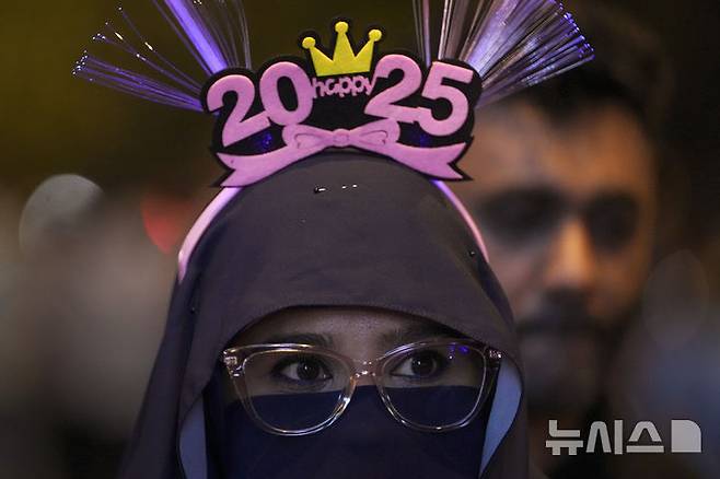 [쿠알라룸푸르=AP/뉴시스] 지난해 12월 31일(현지시각) 말레이시아 쿠알라룸푸르의 페트로나스 트윈타워 근처에서 한 여성이 새해맞이 불꽃놀이를 바라보고 있다. 2025.01.01.