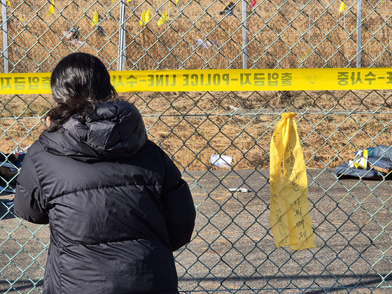 무안 제주항공 참사 나흘째인 1일 전남 무안국제공항 사고 현장 인근에서 한 추모객이 철조망 너머의 참혹한 사고 현장을 지켜보고 있다. 황희규 기자