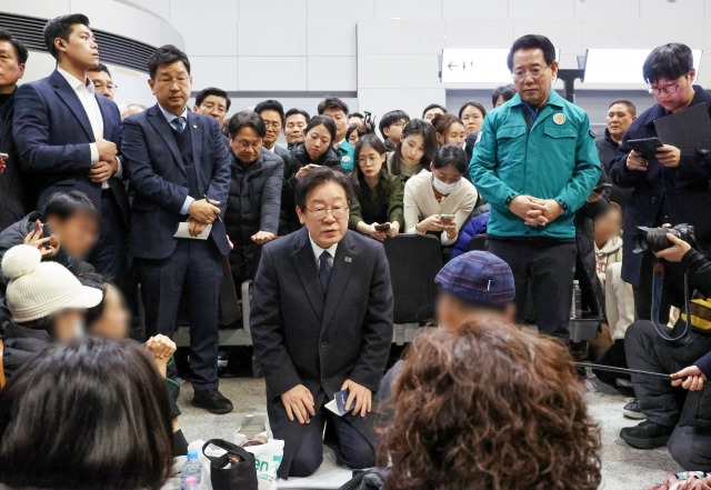 더불어민주당 이재명 대표가 지난달 29일 오후 전남 무안국제공항에서 무릎을 꿇은 채 제주항공 여객기 폭발사고 탑승객 가족들을 위로하고 있다. 연합뉴스