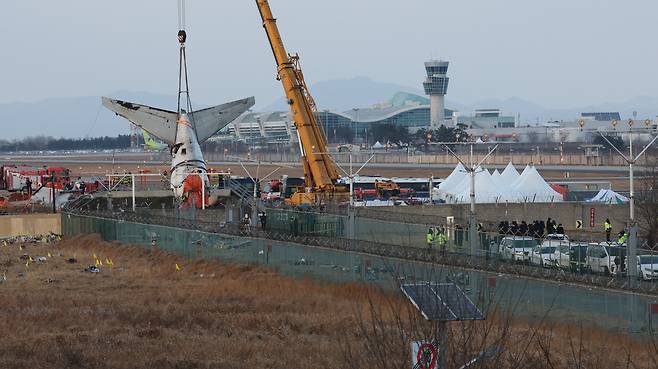 제주항공 여객기 참사 엿새째인 3일 오후 전남 무안국제공항 참사 현장에서 사고 기체의 꼬리 부분이 타워크레인에 의해 인양되고 있다. /뉴스1