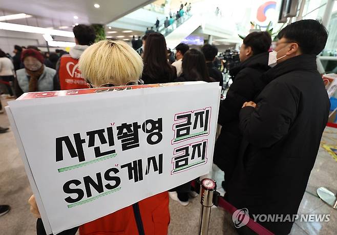 사진 촬영 금지, SNS 게시 금지 (무안=연합뉴스) 김도훈 기자 = 2일 전남 무안군 무안국제공항에 마련된 제주항공 여객기 참사 희생자 합동분향소에서 한 자원봉사자가 사진 촬영 및 SNS 게시 금지를 알리는 안내문을 들고 있다. 2025.1.2 superdoo82@yna.co.kr