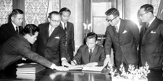 박정희 대통령이 1965년 12월 18일 청와대에서 광복 후 처음 일본과 국교를 회복하고 배상권 등 과거사 문제를 일거 처리하는 내용의 한일협정 비준서에 서명하고 있다. /국가기록원