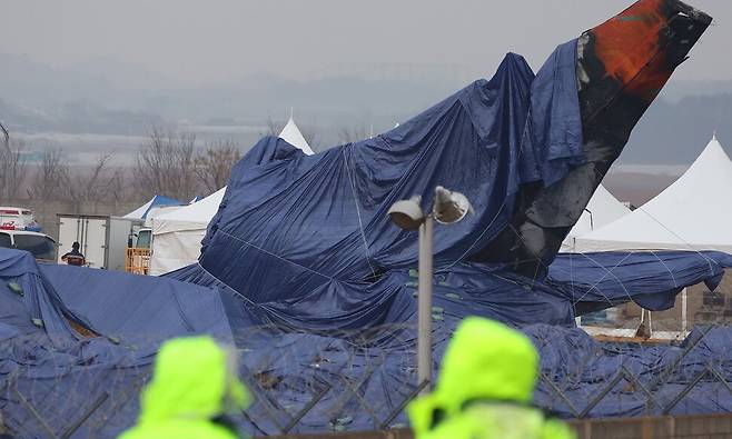 제주항공 여객기 참사 8일째인 5일 비가 내리는 무안국제공항 사고 현장과 꼬리 날개에 방수포가 덮여 있다. 연합뉴스
