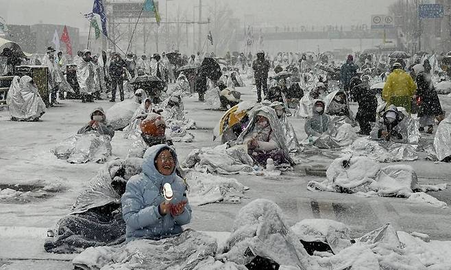 서울 전 지역에 대설주의보가 내려진 5일 아침 서울 용산구 관저 인근 ‘노동자 시민 윤석열 체포대회’ 농성장에서 은박 담요를 뒤집어쓴 시민들이 농성하고 있다. 정혜경 진보당 의원실 제공