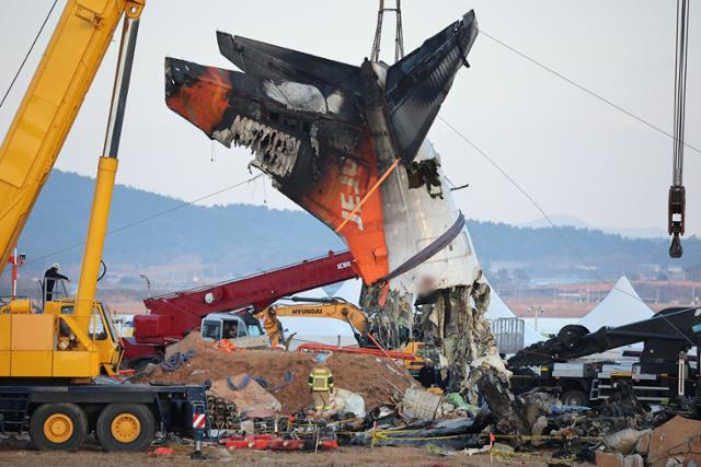 제주항공 여객기 참사 엿새째인 3일 오후 전남 무안국제공항 참사 현장에서 사고 기체의 꼬리 부분이 타워크레인에 의해 인양되고 있다. 뉴스1