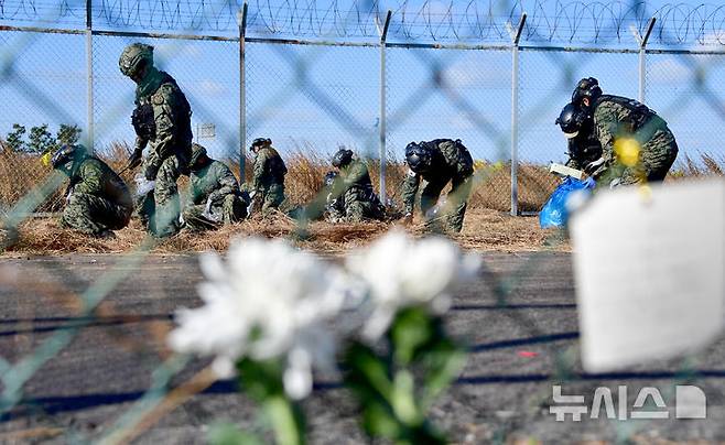 [무안=뉴시스] 류형근 기자 = 2024년 마지막 날인 31일 오전 전남 무안군 무안국제공항 제주항공 여객기 참사 현장에서  특수전사령부 전문재난구조부대 대원들이 유류품 등 수색 작업을 하고 있다. 2024.12.31. hgryu77@newsis.com