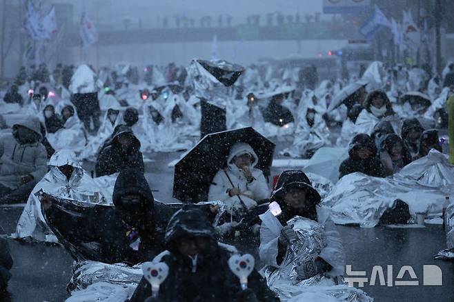 [서울=뉴시스] 정병혁 기자 = 5일 서울 용산구 대통령 관저 인근에서 열린 1박 2일 민주노총 철야투쟁에서  시민들이 은박 비닐을 덮은 채 참석해 있다. 2025.01.05. jhope@newsis.com