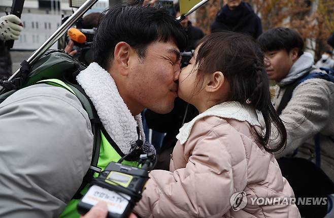 ‘사랑아, 사랑해’ (서울=연합뉴스) 윤동진 기자 = 국내에는 치료법이 없는 희귀병을 앓고 있는 네 살 딸 사랑이의 치료비용을 위해 전국 곳곳을 돌며 후원을 요청하고 있는 전요셉 씨가 29일 오후 최종 목적지인 서울 광화문광장에 도착, 마중 나온 사랑이와 뽀뽀를 하고 있다. 2024.11.29 mon@yna.co.kr