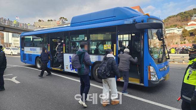 3일 오전 지팡이를 짚은 한 시민이 용산구 한남동 일대 버스 정거장에서 도로 위로 나와 버스에 탑승하고 있다.