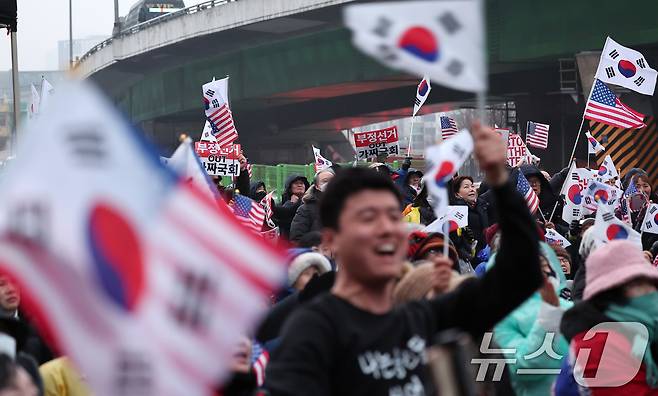 윤석열 대통령의 체포영장 유효기간 마지막 날인 6일 서울 용산구 한남동 대통령 관저 인근에서 윤석열 대통령 지지자들이 '공수처의 체포영장 집행 관련 경찰 일임 기사'를 접한 후 환호하고 있다. 2025.1.6/뉴스1 ⓒ News1 김성진 기자