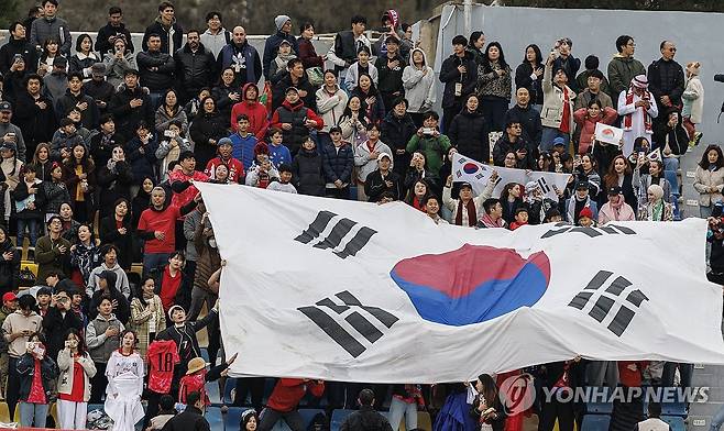 이역만리 태극 전사 응원 나선 교민과 응원단 (암만[요르단]=연합뉴스) 황광모 기자 = 19일 오후(현지시간) 요르단 암만 국제경기장에서 열린 2026 북중미 월드컵 아시아 3차 예선 B조 한국과 팔레스타인의 경기.
   한국 축구대표팀 선수들이 경기장에 입장하자 붉은 악마 응원단과 교민들이 태극기를 펼치고 응원하고 있다. 2024.11.20 hkmpooh@yna.co.kr