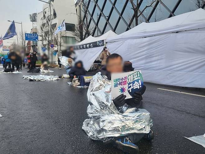 6일 오후 진보 단체 집회에 참석한 김모(61)씨가 '내란수괴 윤석열 체포! 구속!'이라고 적힌 팻말을 들고 있다.ⓒ데일리안 허찬영 기자