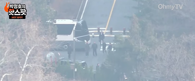 내란혐의로 수사를 받는 윤석열 대통령으로 추정되는 인물이 8일 오마이TV 카메라에 포착됐다. 차량 앞쪽에 팔과 다리를 벌린 채 서 있는 인물이 윤 대통령 추정 인물. /오마이TV 유튜브