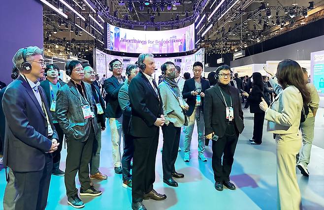 S-Oil CEO Anwar Al-Hejazi (center) listens to a presentation at the Samsung SDS booth at CES 2025 in Las Vegas on Tuesday. (S-Oil)