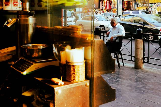 정신없이 흘러가는 다운타운의 오후. 향신료 가게의 주인아저씨가 말없이 거리를 바라본다