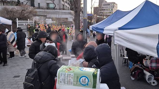 9일 오전 7시 30분께 서울 용산구 한남동 인근에서 집회 참가자들이 아침 식사를 위해 배식을 기다리고 있다. 김도윤 기자.