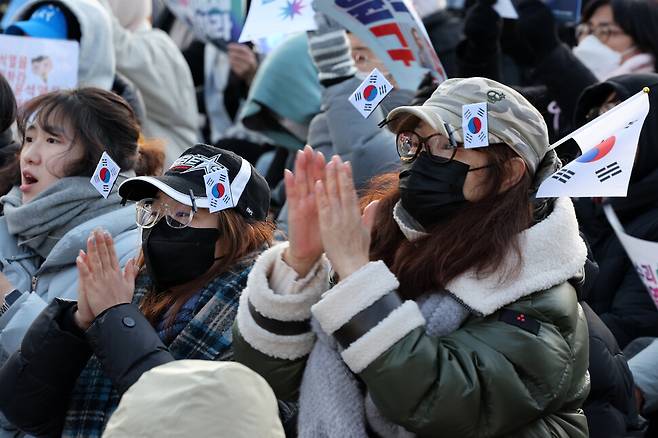 정아무개(30·왼쪽)씨와 정씨 어머니가 모자에 태극기를 달고 11일 오후 서울 종로구 광화문 동십자각 일대에서 열린 범시민총궐기대회에 참석해 박수 치고 있다. 김영원 기자 forever@hani.co.kr