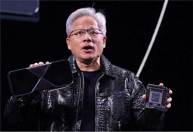 젠슨 황 엔비디아 CEO가 ‘CES 2025’ 개막을 하루 앞둔 1월 6일(현지 시간) 미국 네바다주 라스베이거스 만달레이베이 컨벤션센터에서 한 기조연설에서 최신 인공지능(AI) 가속기 ‘블랙웰(Blackwell)’을 탑재한 지포스 RTX 50 시리즈 그래픽카드를 공개하고 있다. [뉴스1]