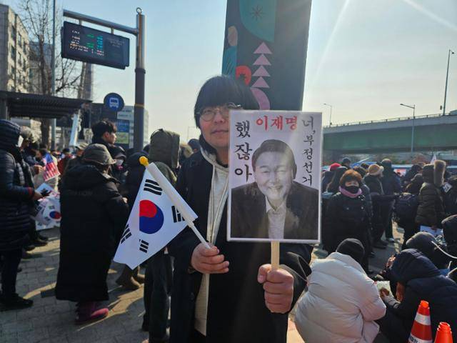 12일 서울 용한구 한남동 윤석열 대통령 관저 인근에서 조승한씨가 손팻말을 들고 있다. 전유진 기자